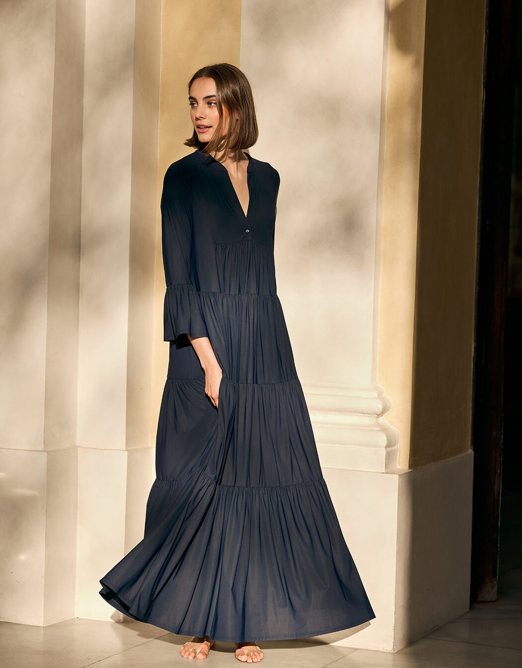 Model standing in the Liora Midnight Blue dress in jersey lycra with a tiered maxi skirt.