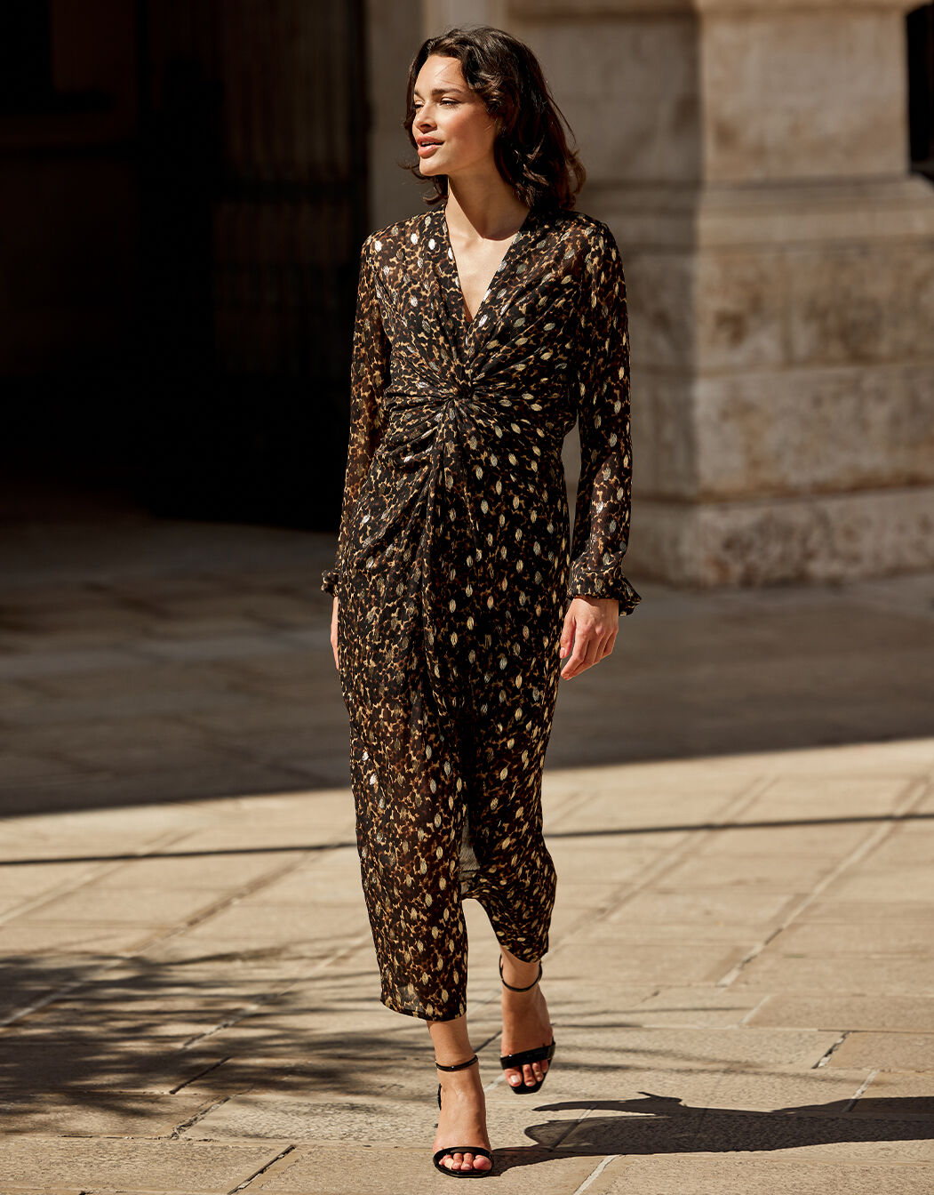 Model walking in the Solene Wild Cat Gold dress in chiffon with an animal print.