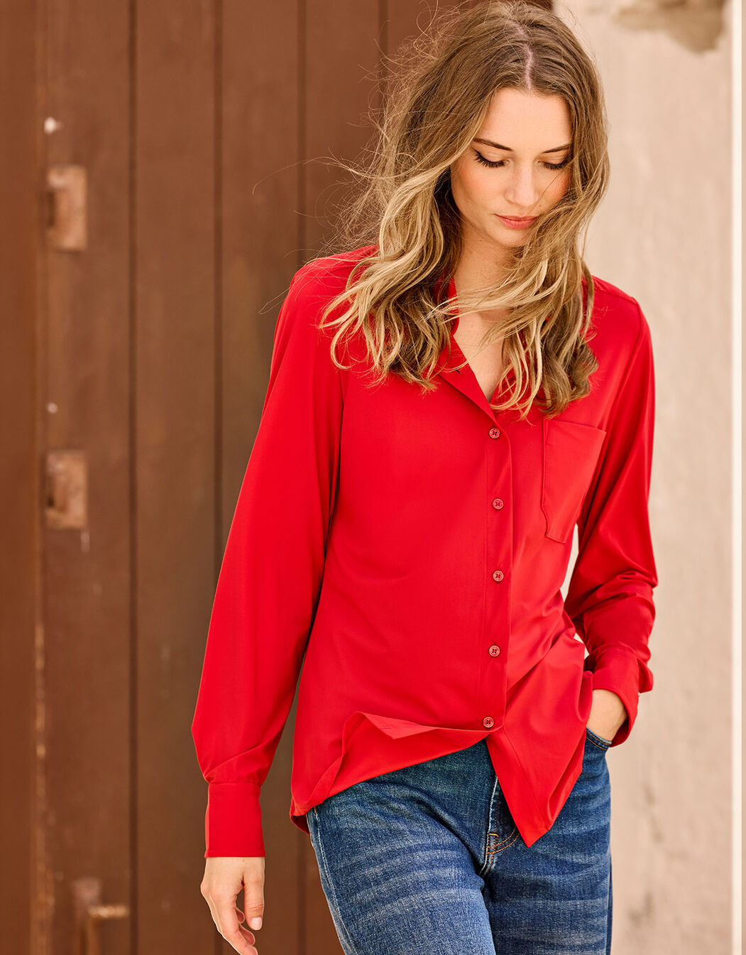 Model wearing the Annie Raspberry Red shirt in jersey lycra with blue jeans.