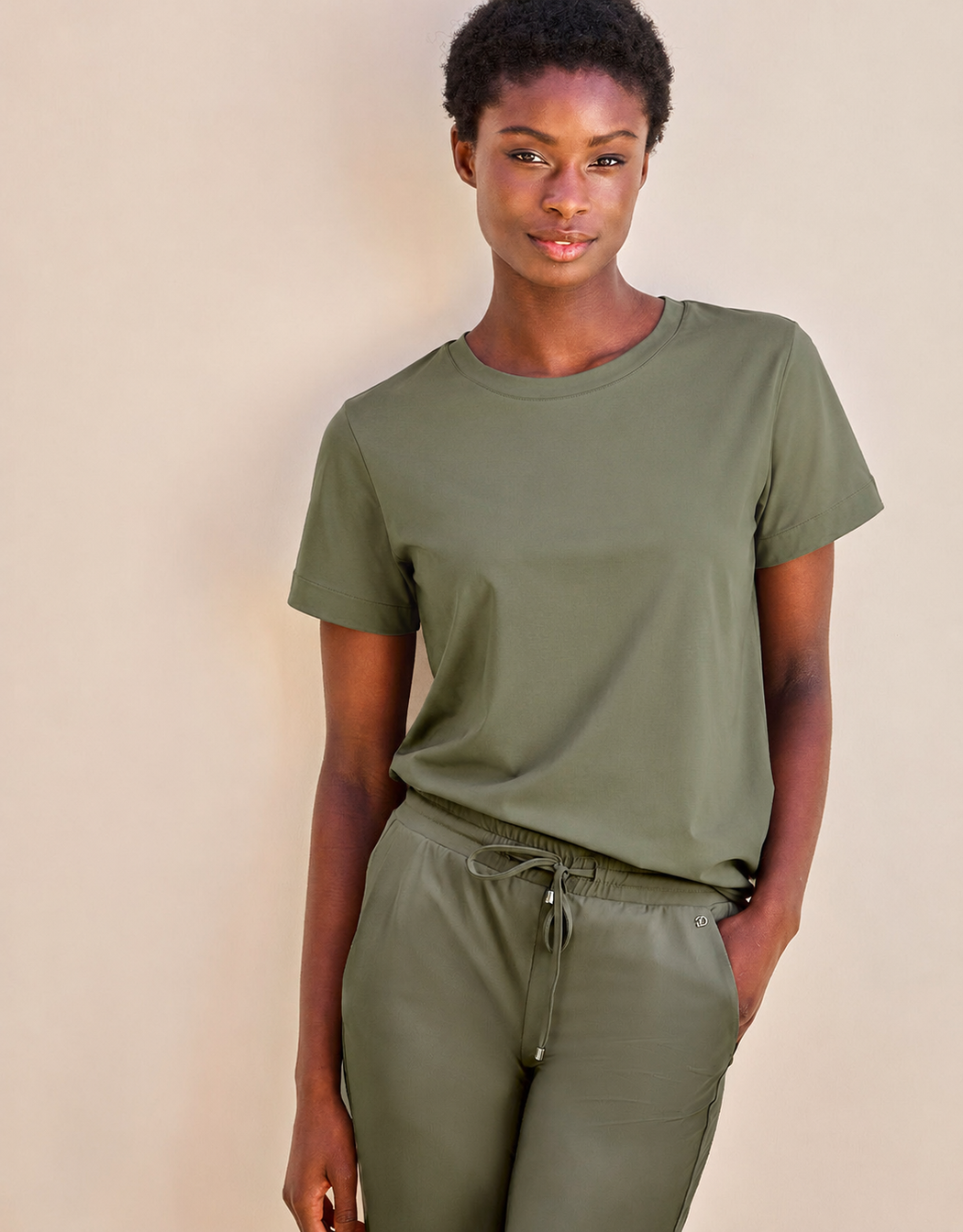 Model standing in the Faith Olive T-shirt in cotton heavy with matching drawstring trousers.