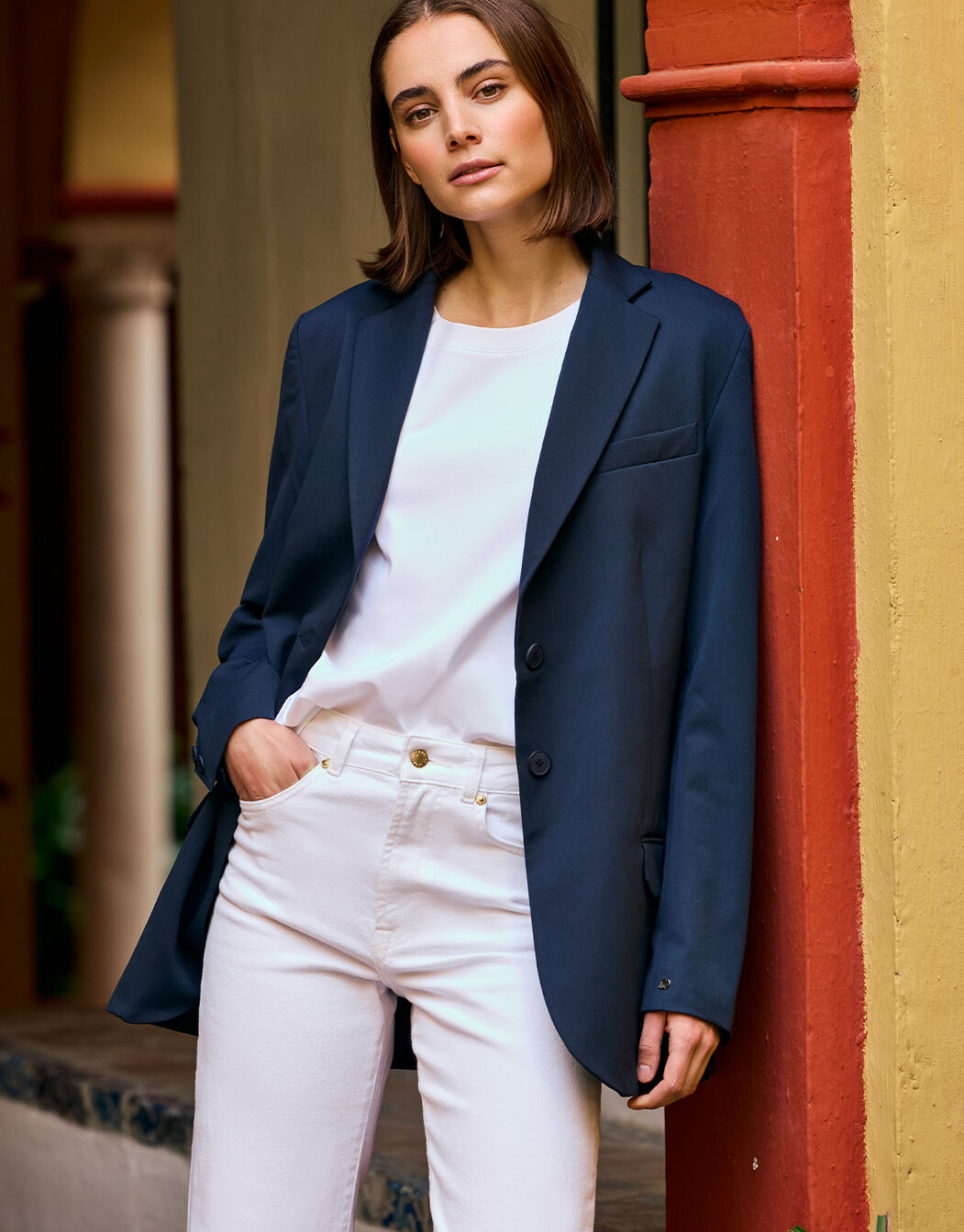 Model wearing the Beau Navy blazer over a white top with white jeans.