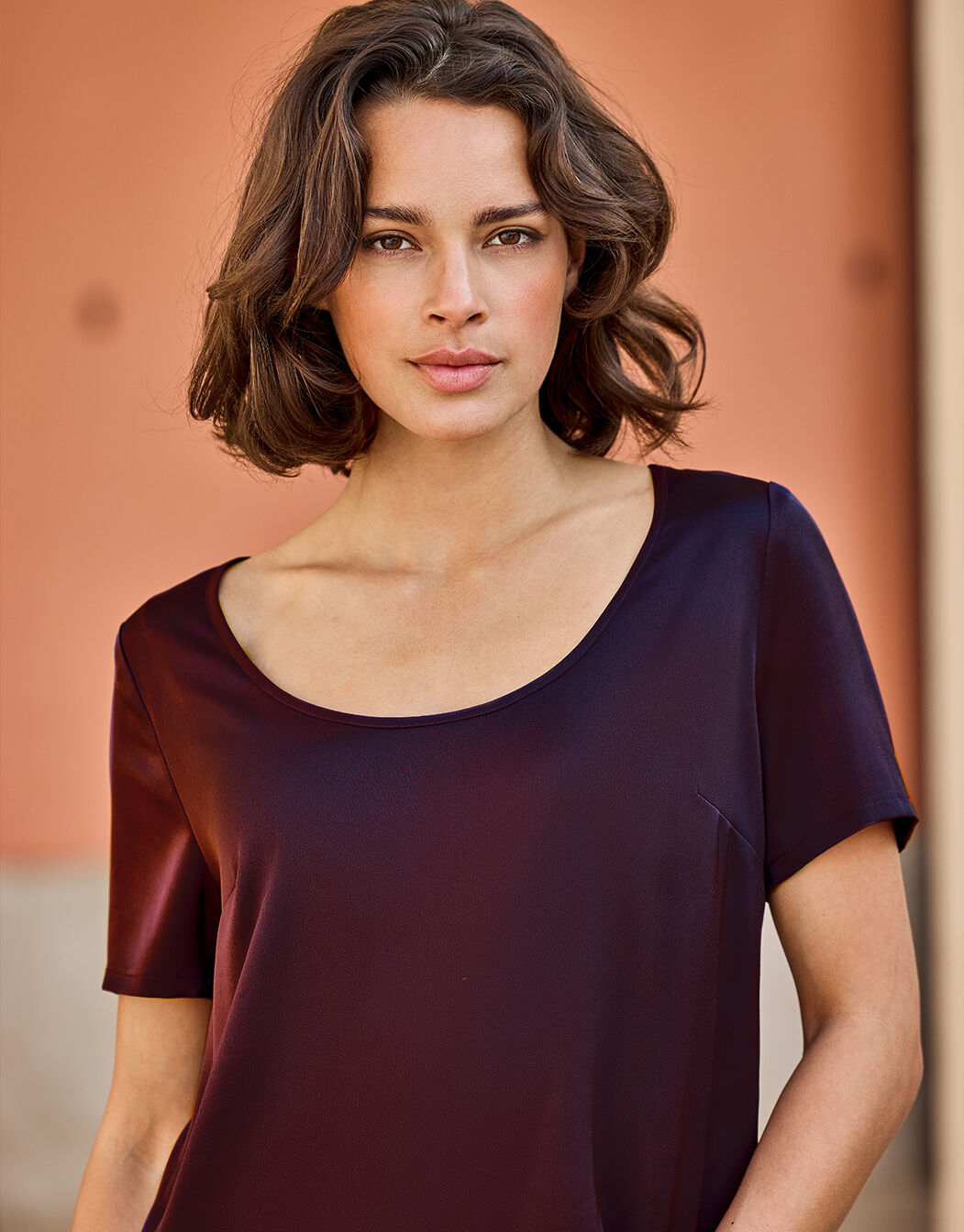Detail of the Doreen Deep Aubergine top in satin, showing the wide scoop neckline.