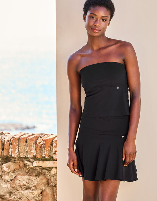Model standing in the Joy Black top in jersey lycra, a strapless bandeau style.