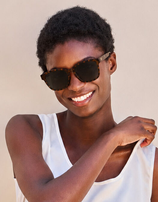 Model outdoors wearing the Ann Tortoise sunglasses with a tortoiseshell frame.
