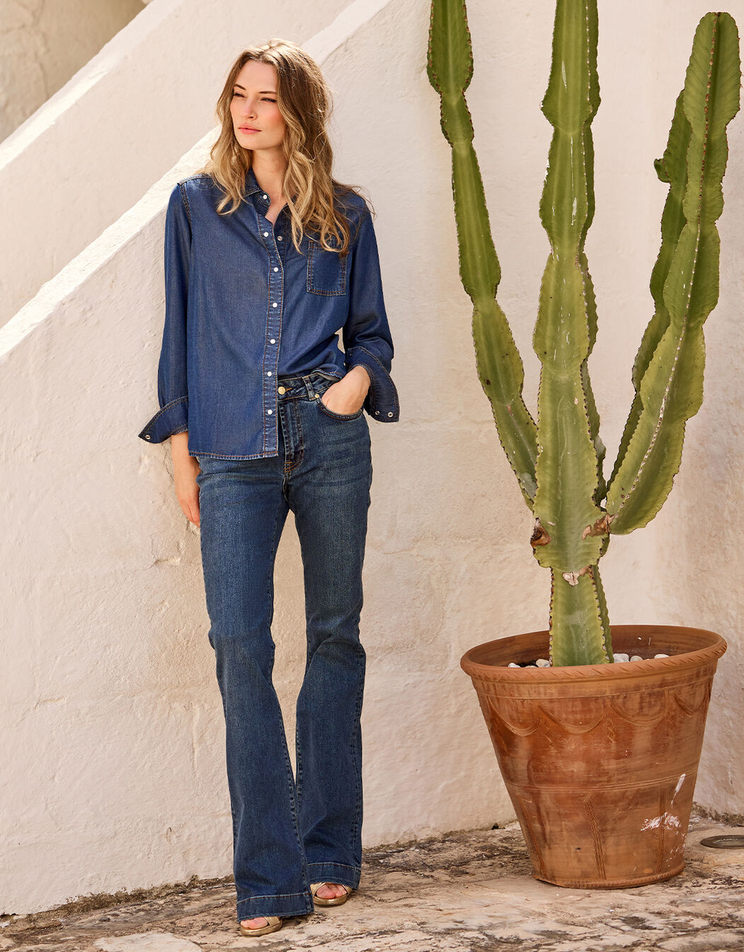 Model standing in the Madelin Dark Indigo jeans in stretch cotton with a denim shirt.