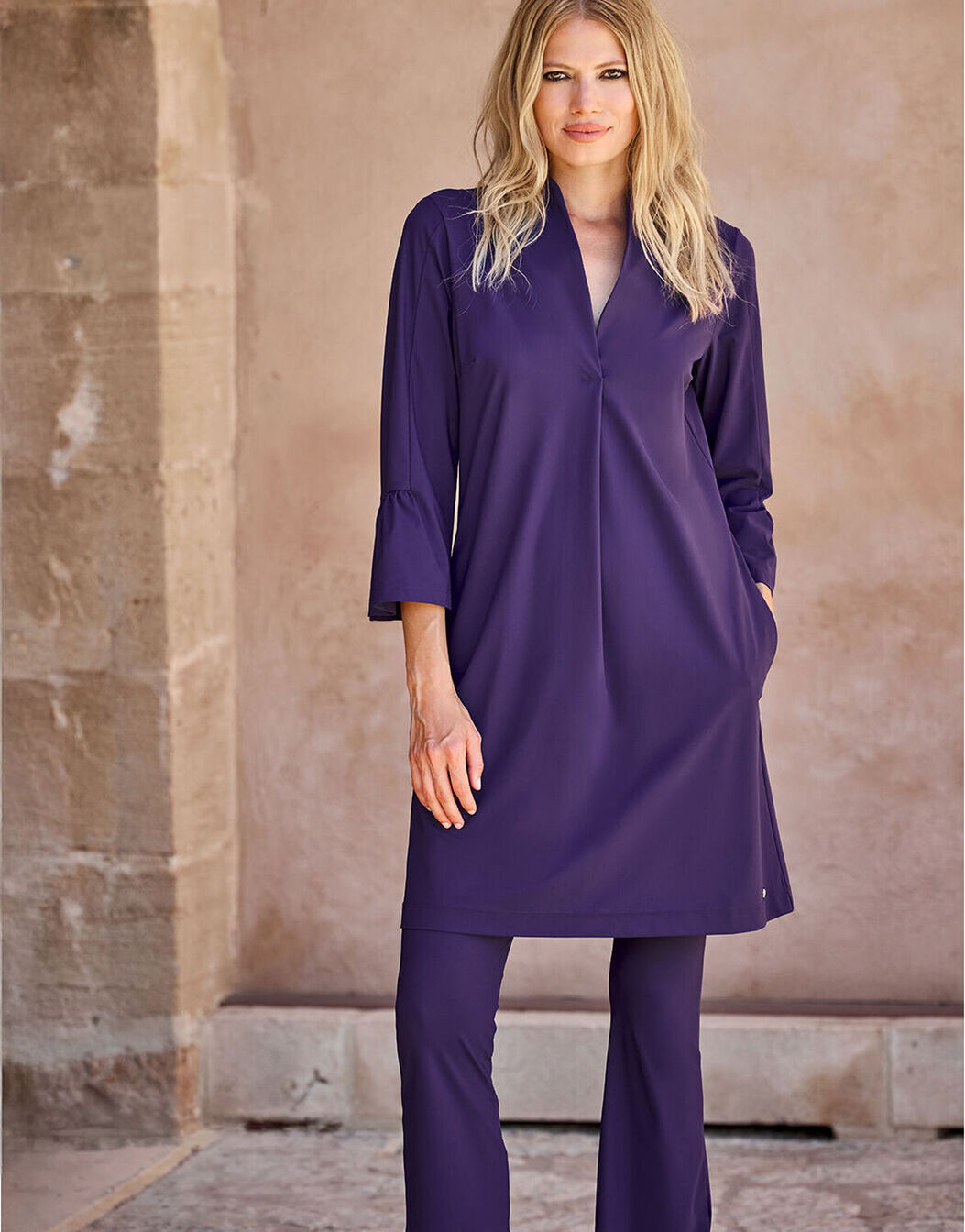 Model standing in the Calista Purple Night dress in jersey lycra, worn over matching trousers.