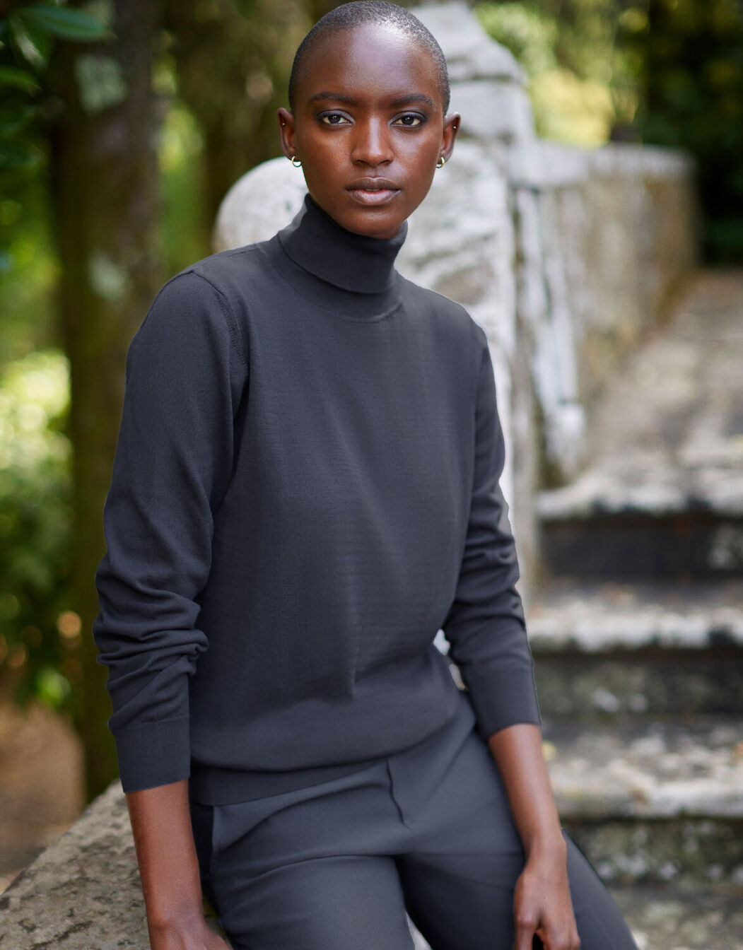 Model standing in the Jackie Antra jumper in organic certified cotton with a roll neck.