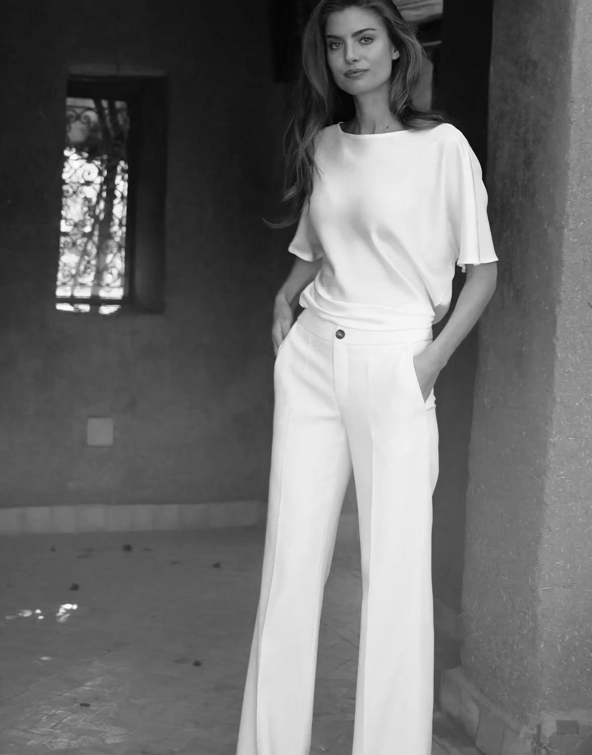 Video of a model wearing crepe satin trousers, shown on the Geneva Coral product page.