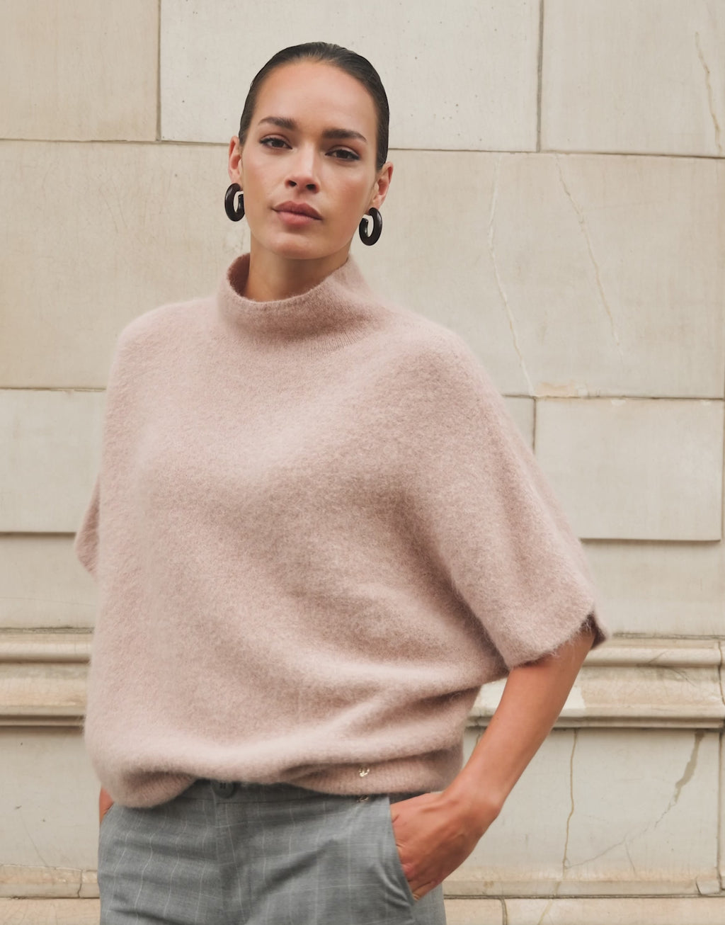Video of a model wearing the Emmy Camel jumper in alpaca blend, seen from the back.