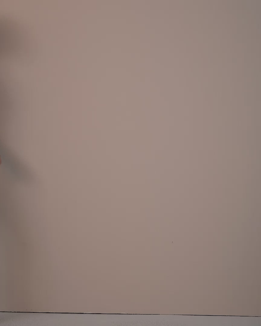 Video of a model wearing the Eloise Plum blouse in satin with black trousers, seen in profile.